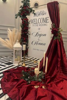 a welcome sign is set up with candles and flowers on the table in front of it