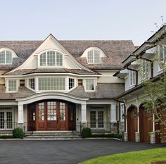 a large house with lots of windows on the front and side of it's roof