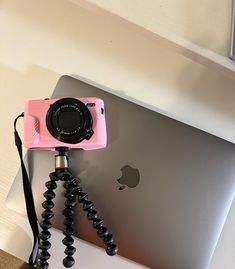 a pink camera sitting on top of an ipad