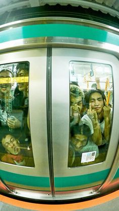 people are taking pictures in the reflection of their mirrors as they ride on a subway train