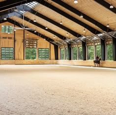 an indoor arena with horses in it