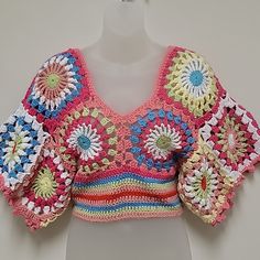 a crocheted crop top on a mannequin's head with flowers