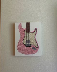 a painting of a pink guitar on a white wall