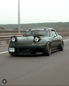 a green sports car driving down the road