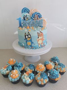 a birthday cake and cupcakes on a table