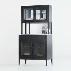 a black cabinet with two glass doors and some shelves on it's sides, in front of a white background