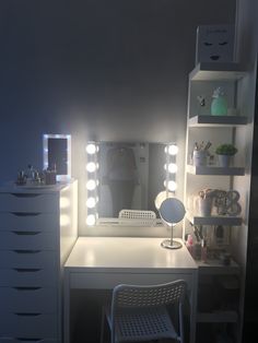 a white desk topped with a mirror and a light on it's shelf next to a chair