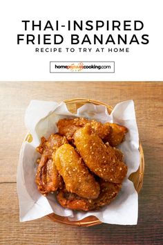 a basket filled with fried bananas sitting on top of a wooden table next to a white napkin