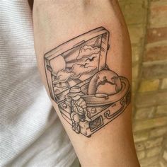 a man with a tattoo on his arm has a suitcase filled with food in it