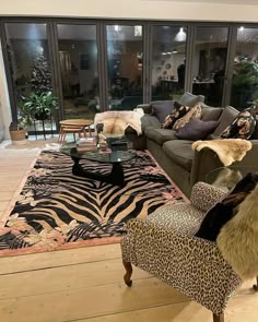 a living room filled with furniture and a zebra rug on top of a hard wood floor