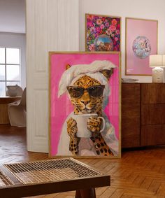 a leopard wearing sunglasses and holding a cup in front of two paintings on the wall