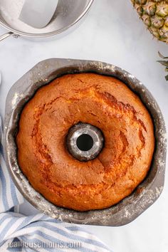 a pineapple bundt cake sitting in a pan on top of a white table