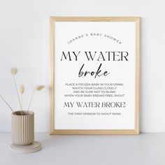 a framed poster with the words my water broke in black on it next to a vase