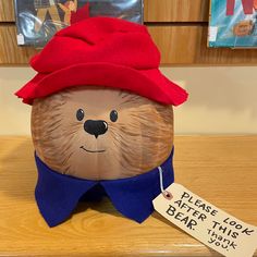 a stuffed bear with a red hat on top of it's head and a price tag