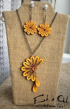 a necklace and earring set made out of wood with yellow flowers on the front