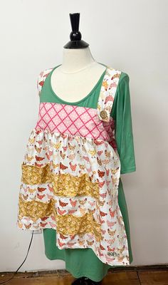 a mannequin wearing a green and pink top with cats on it's chest