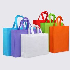 several different colored bags are lined up on a white surface with one bag in the foreground