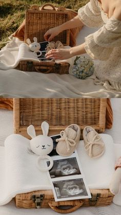 a woman sitting on top of a blanket next to a basket filled with baby items