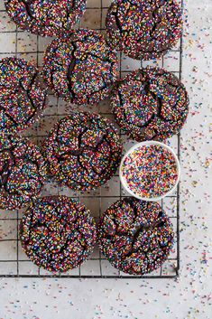 sprinkle covered donuts sitting on a cooling rack