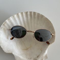 These round oval sunglasses are your everyday classic frames. Featuring a gold metal frame with black reflective lenses. This style is unisex. True genuine vintage sunglasses from the 90s.  - 400 uv  Measurements: Lens height: 37mm Lens width: 51mm Bridge: 22mm Arm temple: 140mm Frame width: 133mm - new vintage from the 90s - includes sunglasses pouch Vintage Sunglasses Aesthetic, Sunglasses Pouch, 25 May, Oval Sunglasses, Classic Frame, Gold Sunglasses, Sunglasses Vintage, Eyewear Sunglasses, New Vintage