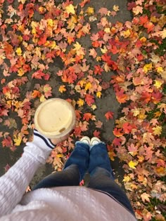 a person standing in front of leaves with a cup