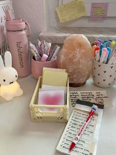 the desk is cluttered with pens, pencils, and other office supplies on it