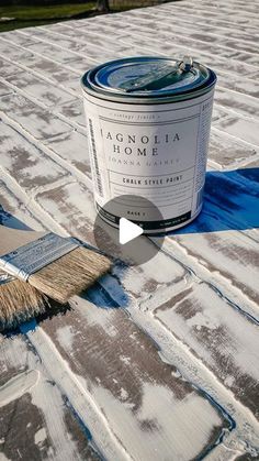 a can of paint sitting on top of a roof next to a brush and cloth