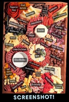 a wooden box filled with lots of different types of cheese and meats on top of it