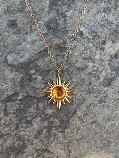 This necklace is handmade with a 19mm by 21mm 14k gold-plated stainless steel pendant and a 6mm genuine citrine cabochon. The chain is 14k gold-filled and will not tarnish.  This necklace is hypoallergenic. (Cadium free, lead free, and nickel safe) Citrine is a stone that promotes positive energy, abundance, and strength. Please note that each stone is unique and varies in color. The necklace comes in a ribbon-tied gift box and if you would like to leave a note, you can do so during checkout. Gold Necklace With Sun Design Round Pendant, Gold Sun Design Round Pendant Necklace, Dainty Gold Citrine Jewelry, 14k Gold Necklaces With Sun Design, Adjustable Gold Cabochon Necklace, Gold Stainless Steel Jewelry With Birthstone, Handmade 14k Gold Yellow Jewelry, Gold-toned Stainless Steel Jewelry With Birthstone, Spiritual Yellow Gold Jewelry With Sun Design