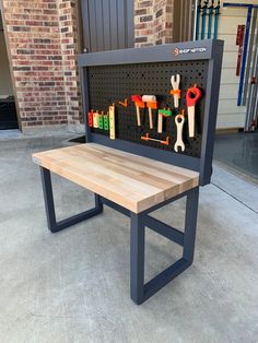 a bench made out of pegboard with tools hanging on the back and underneath it