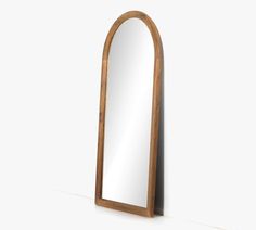 a wooden mirror sitting on top of a white floor