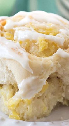 a close up of a piece of cake on a plate with frosting and nuts