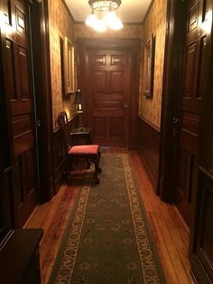 an empty hallway with wooden doors and a bench