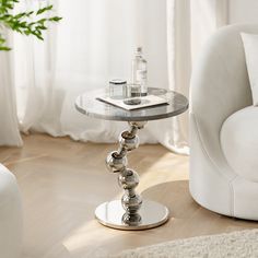 a white chair sitting next to a glass table on top of a hard wood floor