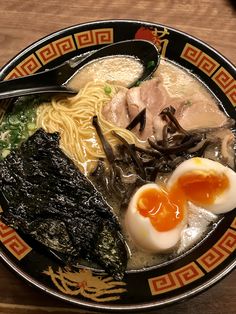 a bowl filled with ramen, meat and an egg on top of broth