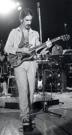 black and white photograph of man playing guitar on stage