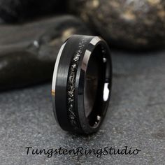 a wedding band with black and white diamonds inlayed to the inside of it