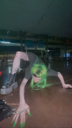 a woman with green hair is doing tricks on a skateboard