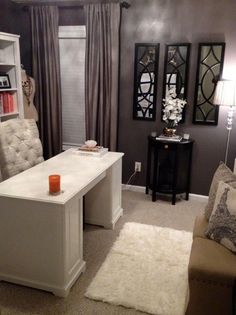 a living room filled with furniture and a white desk in front of a book shelf