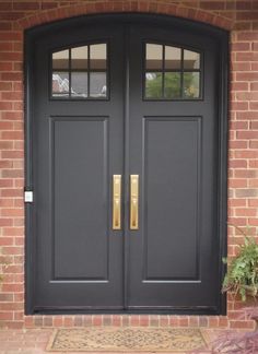 a black front door with two sidelights and gold handles