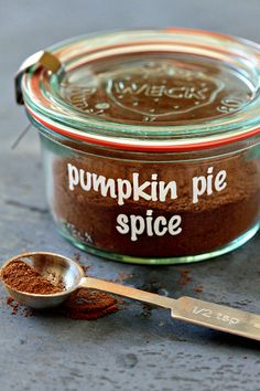 there is a spoon next to a jar of pumpkin pie spice