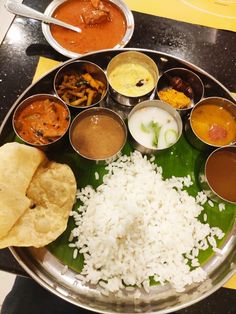 a metal plate topped with lots of different types of food on top of a table