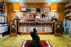 a person's feet resting on a couch in front of a bookshelf