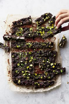 someone is cutting up some brownies with pistachio