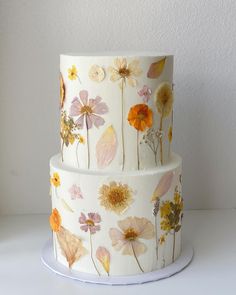 a three tiered cake with flowers painted on it