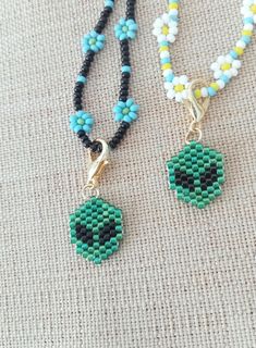 two beaded necklaces are sitting on the ground next to each other, one with an evil eye