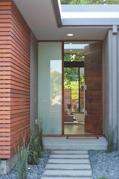 an entrance to a modern home with stone steps