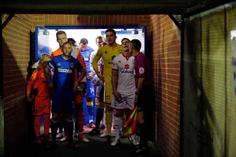 a group of soccer players are standing in the tunnel