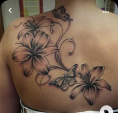 a woman's back with flowers and butterflies on it