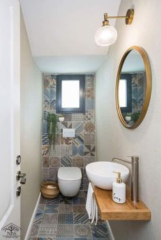 a bathroom with a sink, mirror and toilet in the corner next to a door